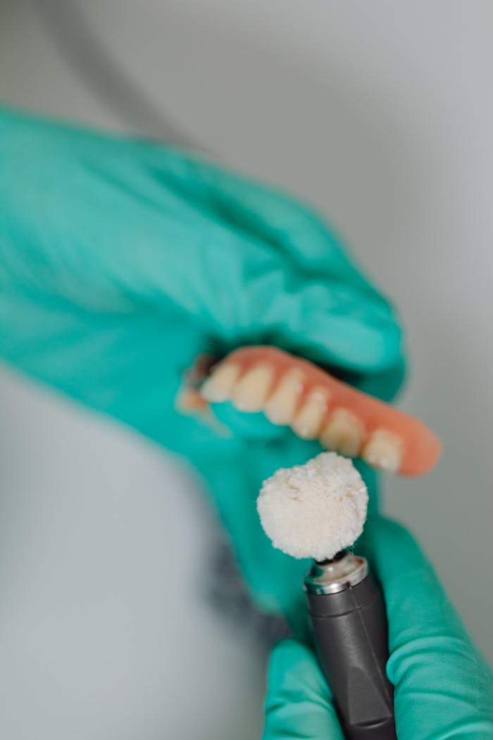 Detailed view of a dental polishing process with dentures and a polishing tool.